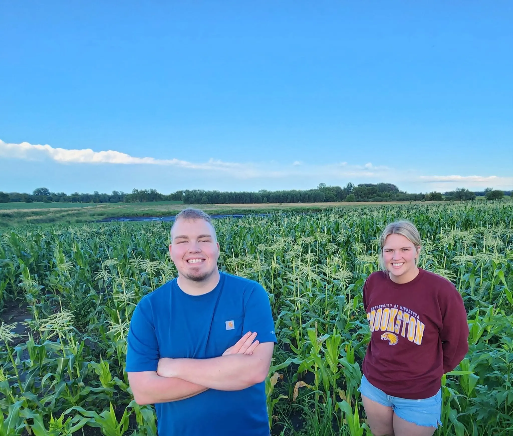 two people standing in a corn field